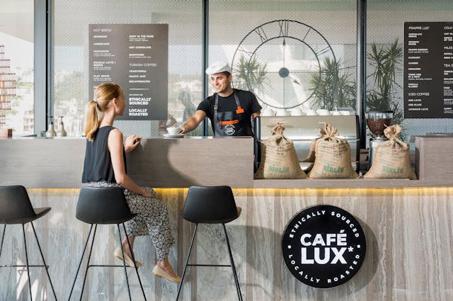 Ein Barista bedient einen Kunden in einem neu eröffneten Café.
