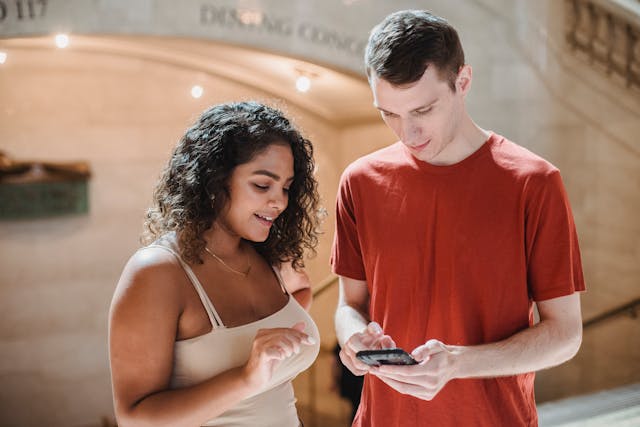 Deux personnes regardant un smartphone.