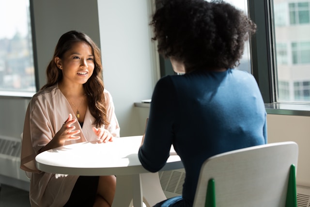 Two women are talking with one another.