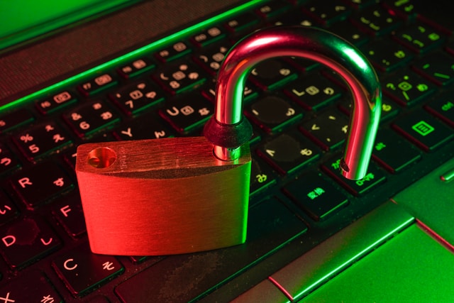 An open lock sitting on a black computer keyboard.