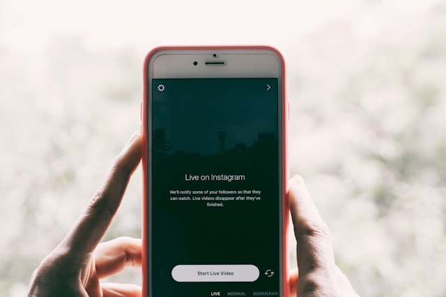 Alguien con un teléfono en la mano mostrando la pantalla Instagram Live y el botón de inicio.