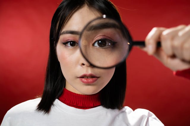 Une femme regardant à travers une loupe.