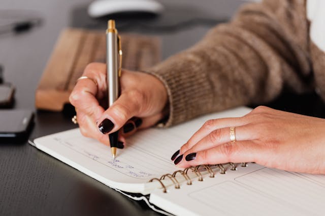 Alguém a escrever a sua estratégia criativa Instagram num caderno.