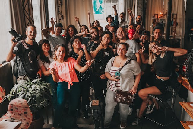 Un grupo de jóvenes diversos sonríen y hacen muecas para una foto.