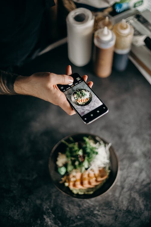 Une personne prenant une photo d'un repas fraîchement préparé. 