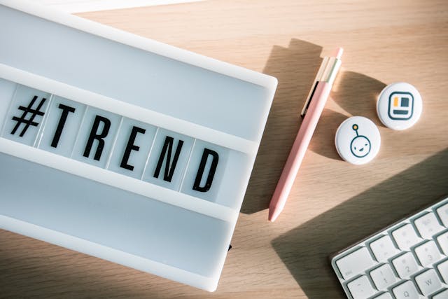 Un tablero con la etiqueta "#TREND" junto a un teclado y un bolígrafo.