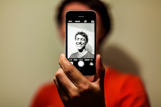 A man taking a black and white selfie on Instagram.