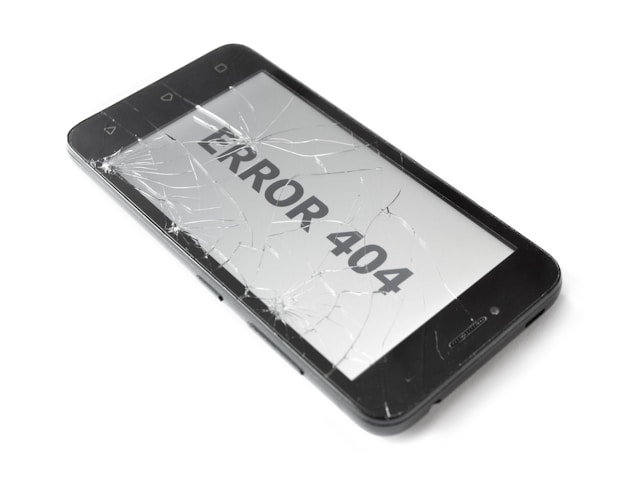 A broken smartphone with the words “ERROR 404” displayed on the screen.