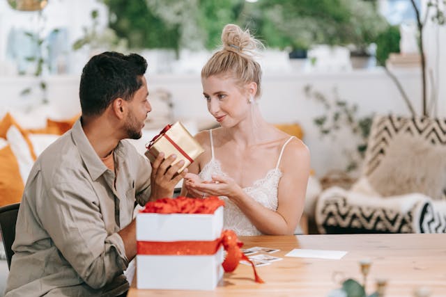 A man about to give his girlfriend a wrapped-up gift.