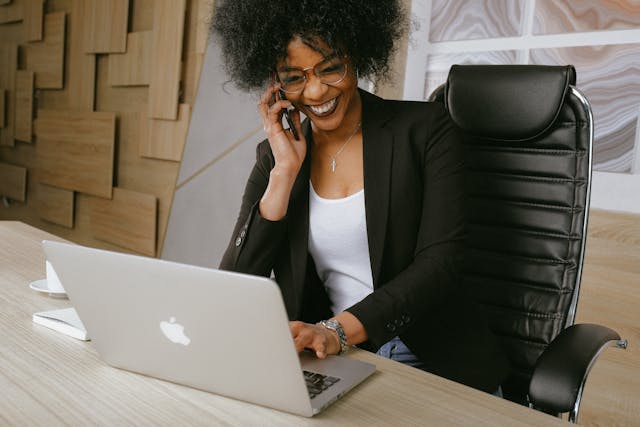 A woman smiling while talking to someone on the phone.