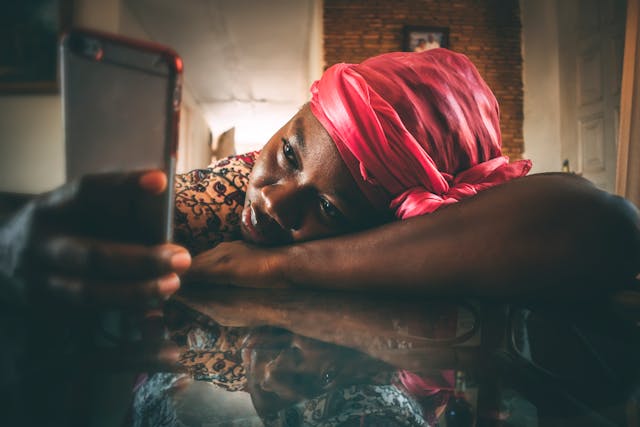 Een verveelde vrouw die naar haar telefoon kijkt.