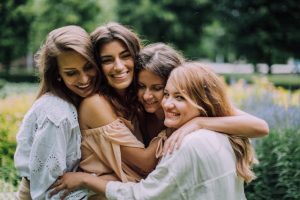 Empat rakan wanita mempunyai pelukan berkumpulan.