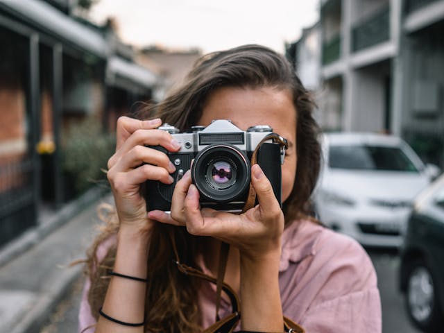 A woman taking a photo with an SLR camera.
