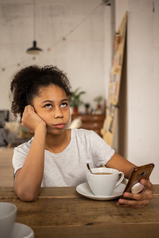 スマホで見ながら目を丸くする10代の少女。