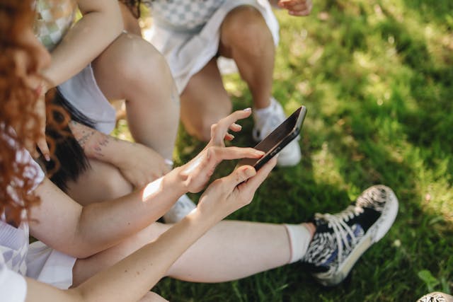 Una vista laterale di una persona che tocca lo schermo del telefono mentre scorre i social media.