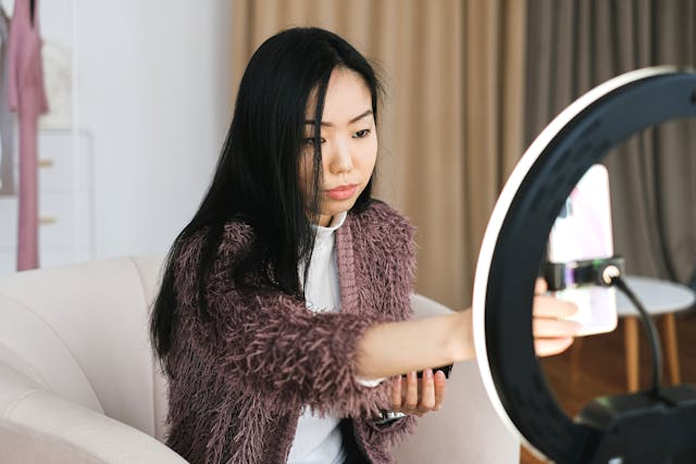 A female influencer positioning her phone as she prepares to film a video.