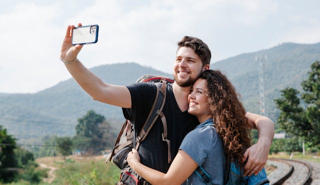 Um homem a tirar uma selfie com a sua namorada durante uma caminhada.