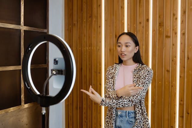 Una influencer grabando un vídeo de sí misma hablando con su teléfono y un trípode.