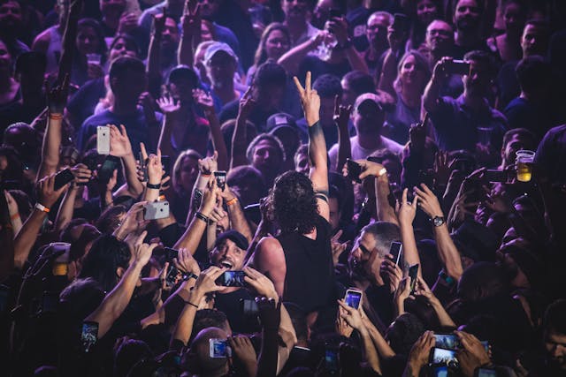 pexels-caricatte-2231750 | Path Social Fans in a crowd gathering and taking photos of a man making a peace sign with his fingers.