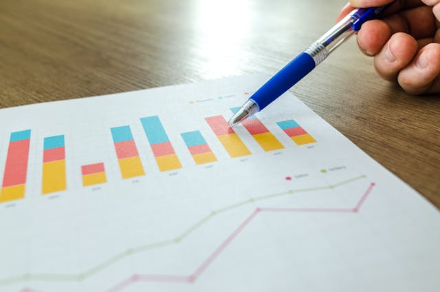 pexels-goumbik-590020 | Path Social Someone pointing at an analytics report with a blue pen on a desk.