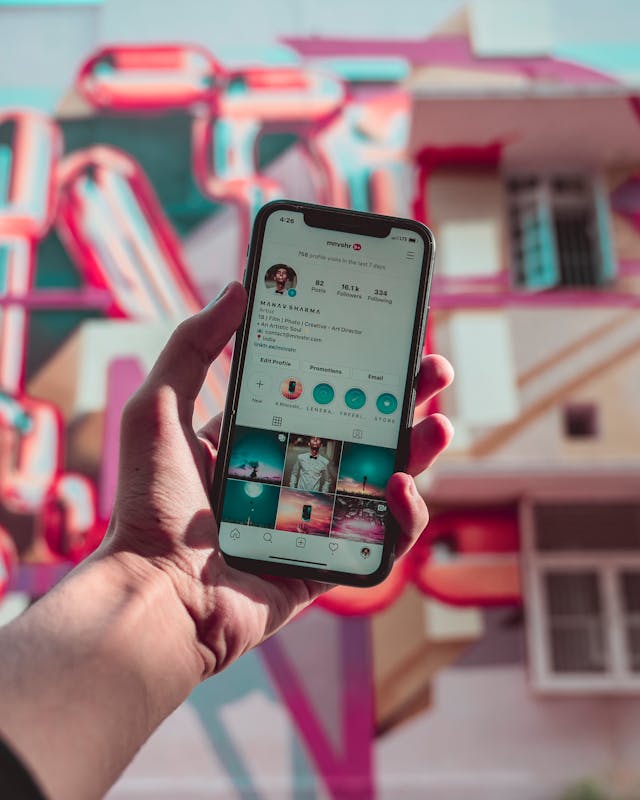 Quelqu'un tient un smartphone avec le profil d'une personne Instagram sur l'écran.