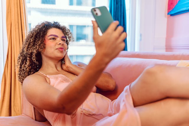 pexels-rdne-7035156 | Path Social ソファに座って自撮りする巻き髪の女性。