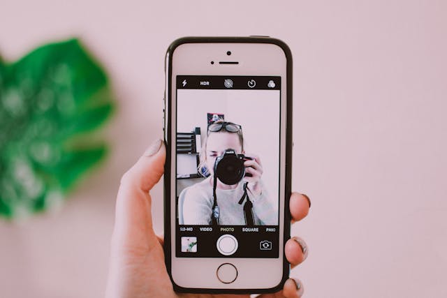 pexels-fotios-photos-1322360 | Path Social Uma mulher de cabelo ruivo sentada numa secretária de escritório a olhar para dados em vários monitores de computador.