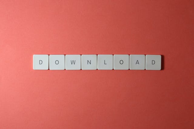 pexels-padrinan-2882550 | Path Social Um grande plano dos botões do teclado com a palavra "DOWNLOAD" num fundo vermelho.