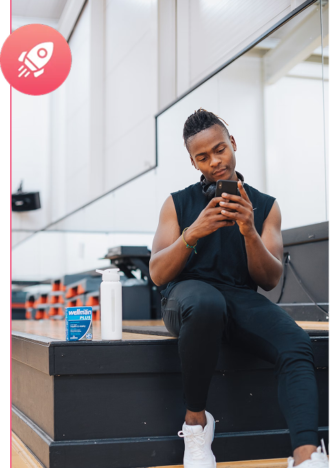 Man in athletic wear sitting outdoors and checking his smartphone after workout